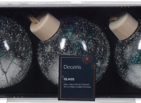 3 διάφανες γυάλινες χριστουγεννιάτικες μπάλες με αποξηραμένα μπλε λουλούδια και χιόνι στο εσωτερικό.