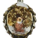 Χριστουγεννιάτικο στολίδι σε σχήμα κουκουνάρι, χρώματος χρυσού. Μέσα σε κόγχη στο κουκουνάρι κάθεται μια κουκουβάγια. Διακόσμηση με άσπρο γκλίτερ χιόνι.