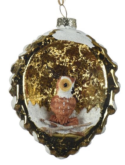 Χριστουγεννιάτικο στολίδι σε σχήμα κουκουνάρι, χρώματος χρυσού. Μέσα σε κόγχη στο κουκουνάρι κάθεται μια κουκουβάγια. Διακόσμηση με άσπρο γκλίτερ χιόνι.