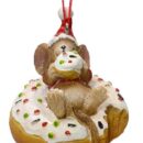 Στολίδι από ρητίνη. Ένα ποντίκι φορά χριστουγεννιάτικο σκούφο και είναι ξαπλωμένο πάνω σε έναν ντόνατ με λευκό γλάσο και πράσινες και κόκκινες τρούφες.