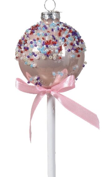 Στολίδι σε σχήμα cake pop χρώματος παλ σομόν. Διακόσμηση με μωβ, γαλάζιες, κόκκινες και λευκές χάντρες. Στο λευκό ξυλάκι είναι δεμένος ένας ροζ φιόγκος.
