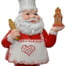 Στολίδι Άγιος Βασίλης ζαχαροπλάστης. Φορά καπέλο σεφ και λευκή ποδιά με κόκκινη καρδιά στη μέση. Στο ένα χέρι κρατά έναν πλάστη και στο άλλο ένα σπίτι από μελόψωμο.