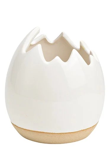 Κρεμ πασχαλινό γλαστράκι σε σχήμα αυγού σπασμένο στο πάνω μέρος όπου μπορείτε να το χρησιμοποιήσετε και ως μπολάκι για σοκολατάκια ή οτιδήποτε άλλο επιθυμήτε .  Έχει  διάσταση 11x12x11 εκ. . Το διαθέτουμε και σε βεραμάν