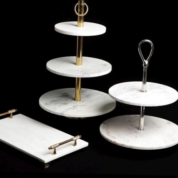 Αναδείξτε τα γλυκά και τα εδέσματά σας με την κομψότητα του λευκού μαρμάρου και τη λάμψη της χρυσής-μπρονζέ βάσης. Η γλυκιέρα δύο επιπέδων είναι ιδανική για την παρουσίαση cupcakes, macarons, φρούτων ή αλμυρών μεζέδων, προσφέροντας πρακτικότητα και αισθητική στο τραπέζι σας. Η στιβαρή κατασκευή και η κομψή χειρολαβή στο πάνω μέρος εξασφαλίζουν άνετη μεταφορά, ενώ ο διαχρονικός σχεδιασμός της ταιριάζει απόλυτα τόσο σε καθημερινές συγκεντρώσεις όσο και σε πιο επίσημα καλέσματα. Ένα κομμάτι που συνδυάζει την πολυτέλεια με την πρακτικότητα, χαρίζοντας στυλ σε κάθε περίσταση.